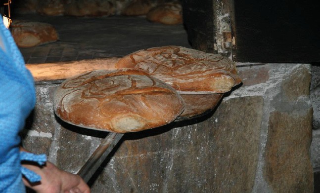 Hogazas de pan junto a un horno tradicional